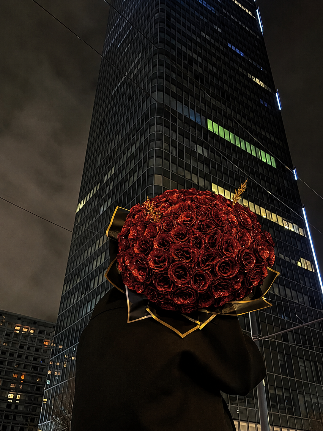 Bouquet de roses éternelles devant un gratte-ciel la nuit